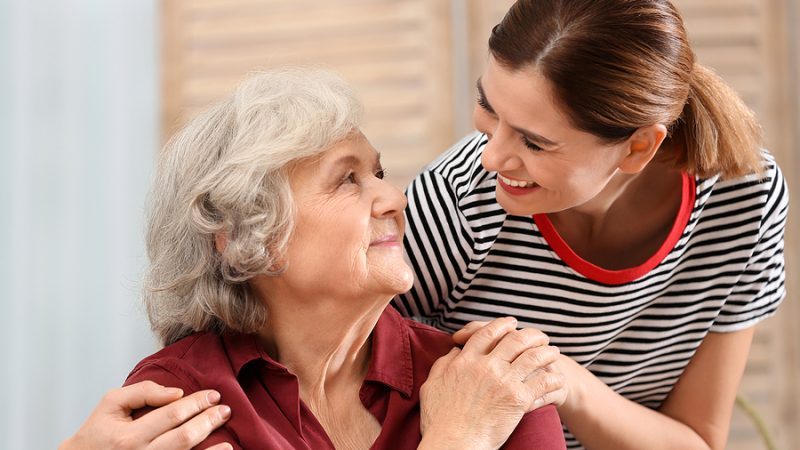 Hospice Care For Dementia. Elderly woman with female caregiver at home.
