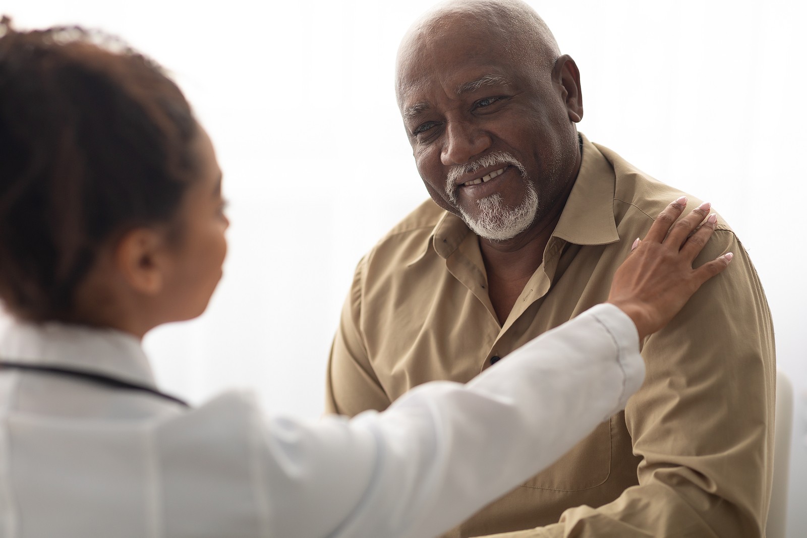 A nurse and elderly hospice patient share a smile together.