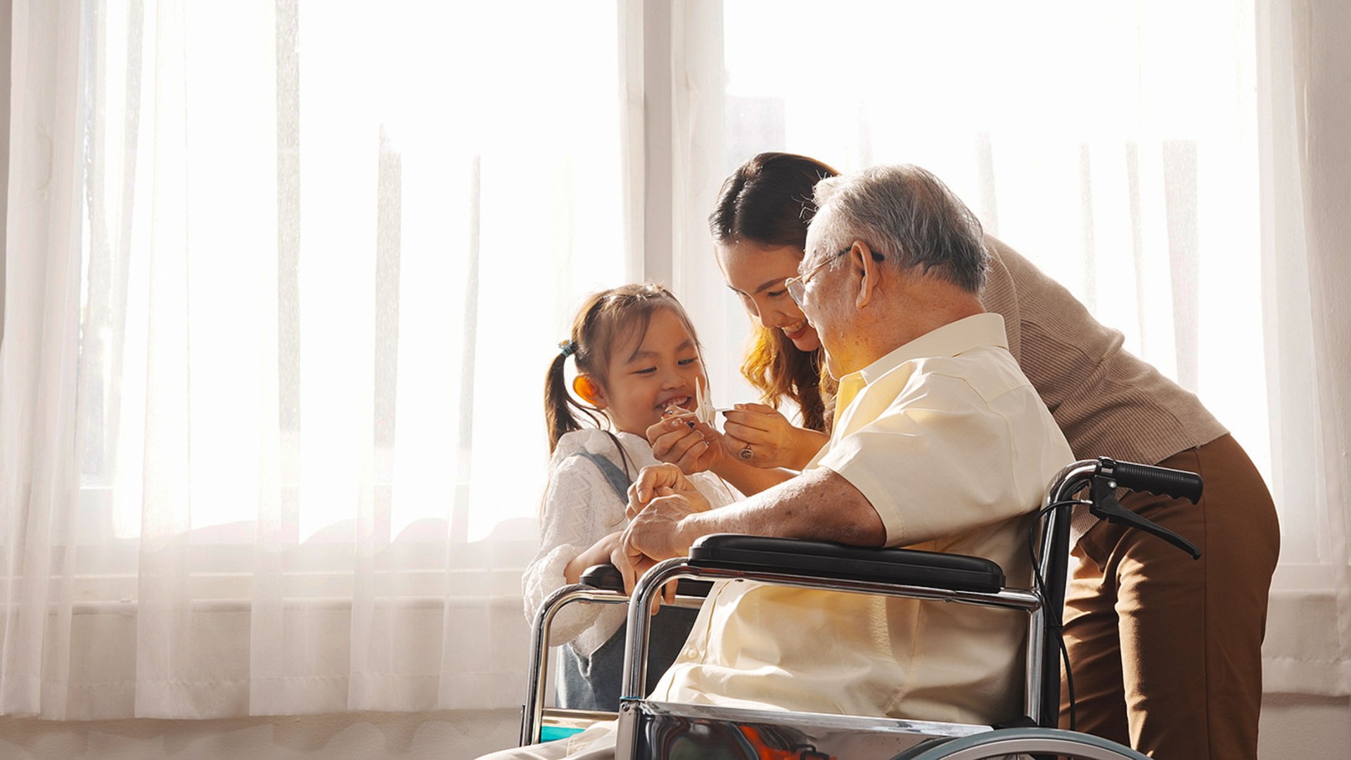 Elderly man and his grandson sharing a bedside smile.